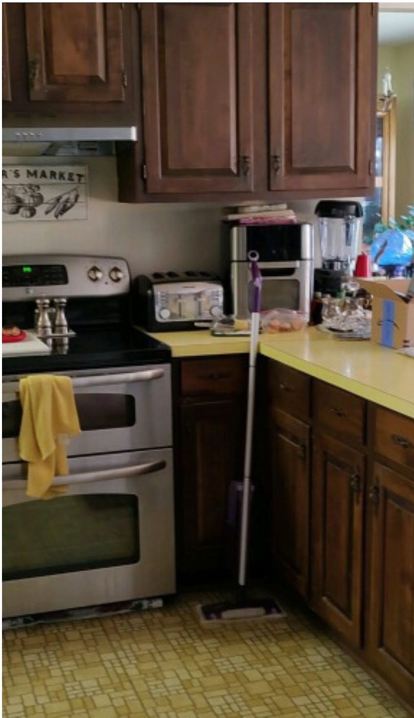 Before: Honey-oak kitchen cabinets painted a warm gray